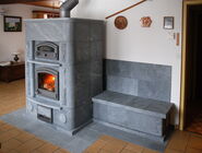 Ein Specksteinofen mit brennendem Ofen und integrierter Ofenbank