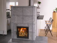 Ein Specksteinofen mit brennendem Ofen und integrierter Ofenbank